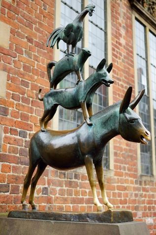 Bronzestatue der Bremer Stadtmusikanten vor einer historischen Backsteinfassade