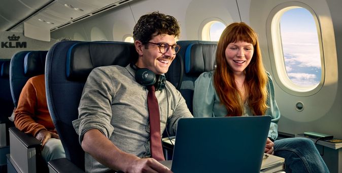 Junges Paar mit Laptop in der KLM Premium Comfort Class