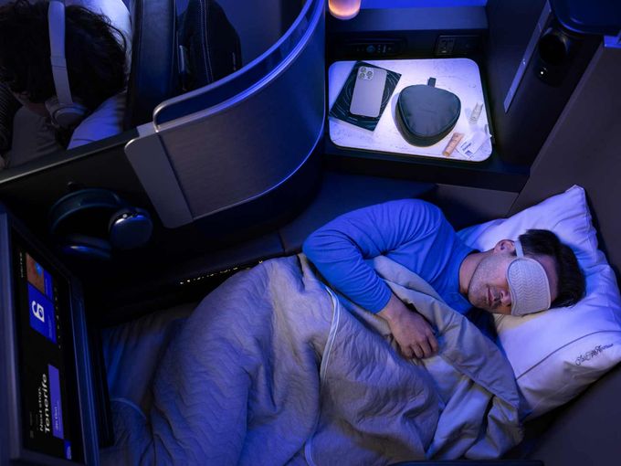 Mann mit Augenmaske schläft in der Polaris Business Class von United im Flatbed