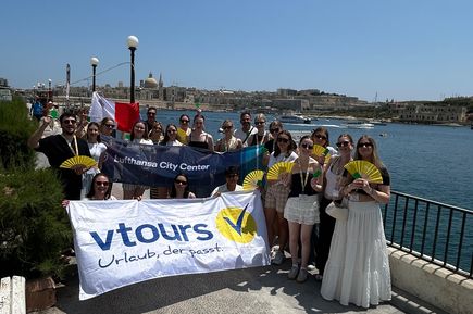 Gruppenfoto mit vtours Banner und gelben Fächern