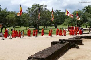 Rotes Gewand tragende Einheimische gehen im Park auf Sri Lanka