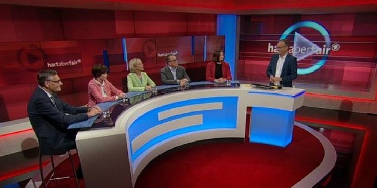 Diskussionsrunde im Fernsehstudio mit mehreren Gästen und Moderator – Symbol für gesellschaftliche Debatten und Austausch zu aktuellen Themen.