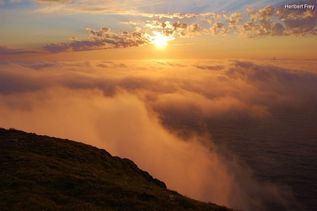 Blick vom Berg auf Wolken und Sonnenuntergang