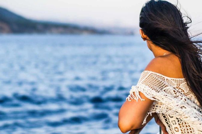 Frau auf Kreuzfahrt blickt auf das Meer