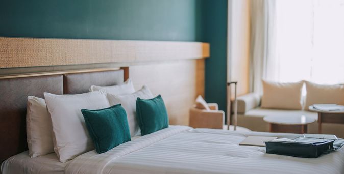 Modern eingerichtetes Hotelzimmer mit großem Bett und warmem Licht.