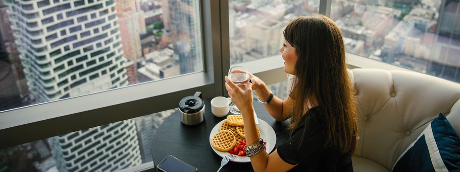 Frau beim Frühstück im Wolkenkratzer