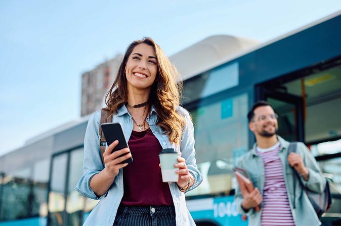 Young woman and young man smiling in front of a building