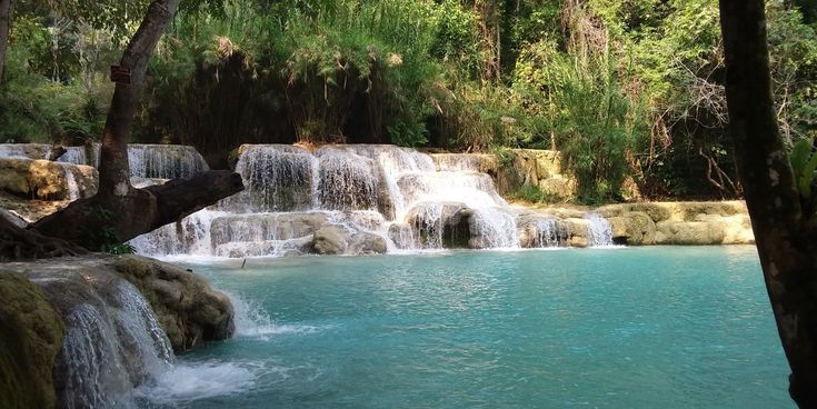 Mehrstufige Kuang-Si-Wasserfälle bei Luang Prabang in Laos mit türkisblauem Wasser und umgebendem tropischem Wald.