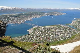 Blick vom Berg auf Meer und kleine Stadt in Nordeuropa