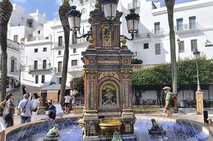 Bunter Brunnen mit kleinen Froschstatuen inmitten der Stadt