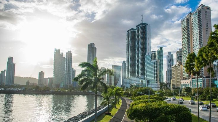 Skyline von Panama-Stadt mit modernen Hochhäusern und palmengesäumter Uferpromenade.