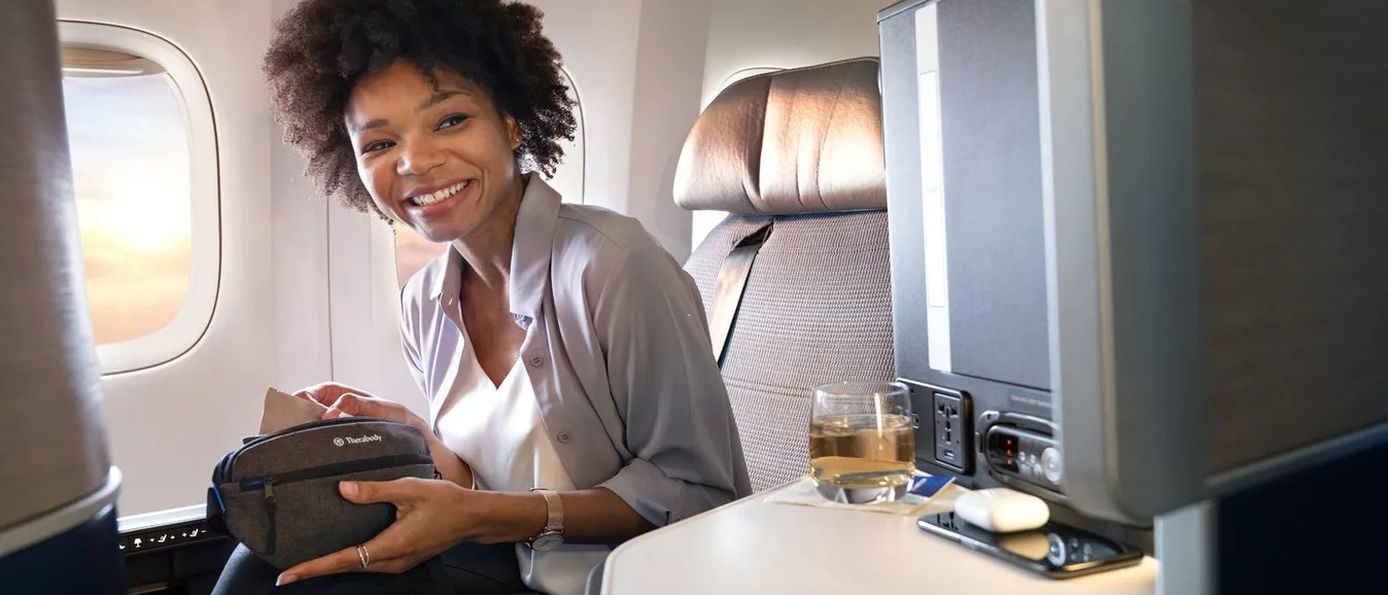 Passagierin in der United Airlines Business Class mit entspanntem Lächeln, Premium-Komfort auf der Strecke Berlin-New York