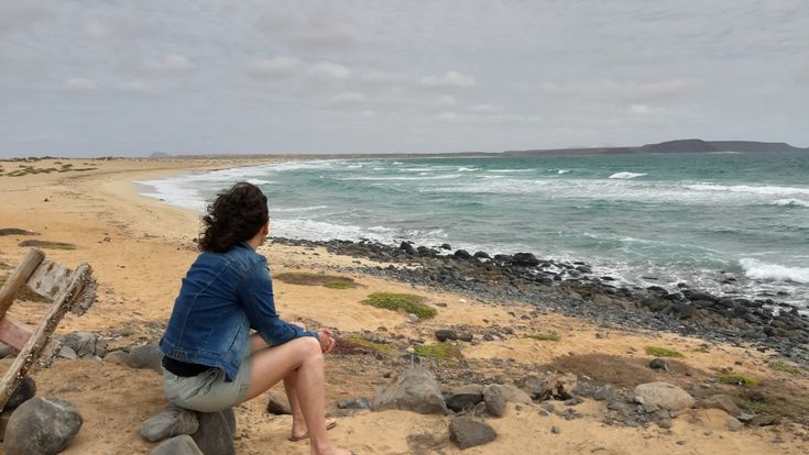 Kornelia Reintges, Reiseberaterin im LCC Niederrhein Alter Markt. Sitzt am Strand mit Blick auf das Meer