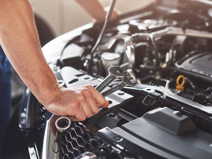 Mechaniker arbeitet mit Werkzeug an Automotor