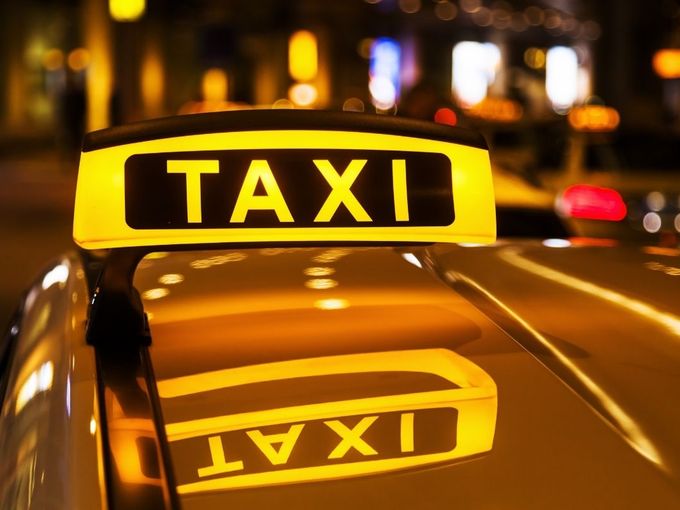 Gelbes Taxi mit leuchtendem Taxi-Schild