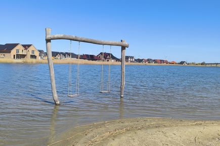 Holzschaukel im seichten Wasser
