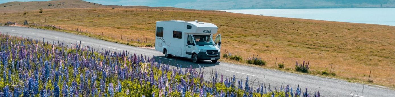 In Neuseeland neben dem See Lake Tekapo fährt ein Camper