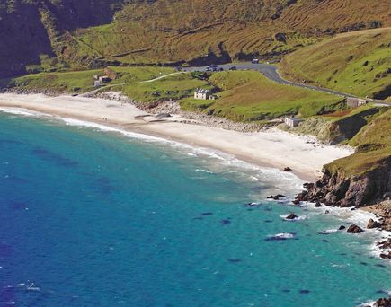 Malerischer Strand mit türkisblauem Wasser und grünen Hügeln auf Achill Island.