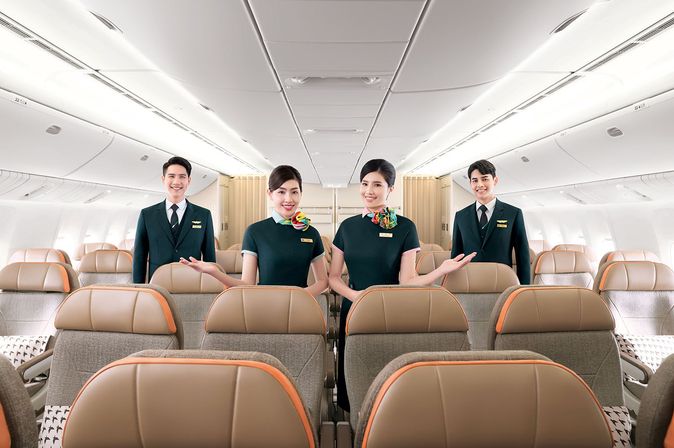 Kabinenpersonal von EVA Air steht im Flugzeuggang zwischen Sitzreihen der Premium Economy Class.