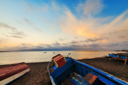 altes kleines Fischerboot liegt am Strand vor dem Meer