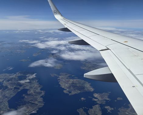 Blick aus dem Flugzeug auf die norwegische Insel- und Küstenlandschaft während des Anflugs.