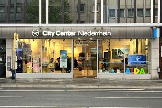 Außenansicht des Reisebüros City Center Niederrhein in der Bismarckstraße mit großen Schaufenstern und Reiseplakaten.