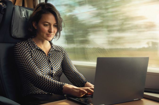 Reisende Frau im Zug © Deutsche Bahn