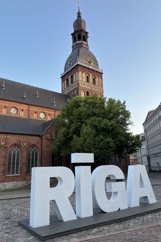 Schild Riga vor einer Kirche mit Turm