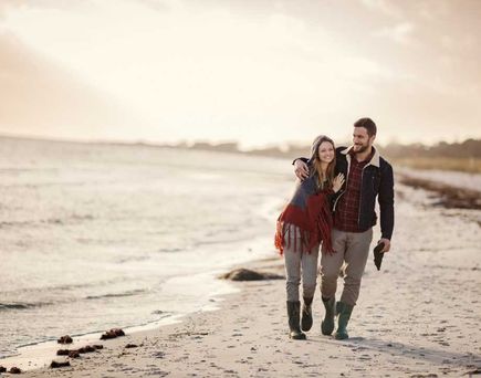 Paar spaziert am Meer im Herbst