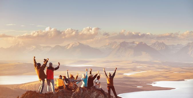 Reisende auf einer Bergspitze mit Blick auf das Panorama