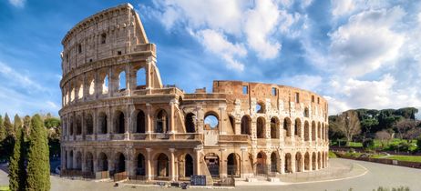 Das berühmte Kolosseum in Rom bei blauem Himmel und Sonnenschein, Symbol der römischen Antike.