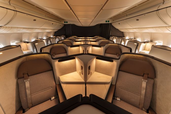 Business-Class-Kabine der Cathay Pacific Aria Suite in Beige-Braun mit 1-2-1-Bestuhlung, Schiebetüren und warmem Ambientelicht