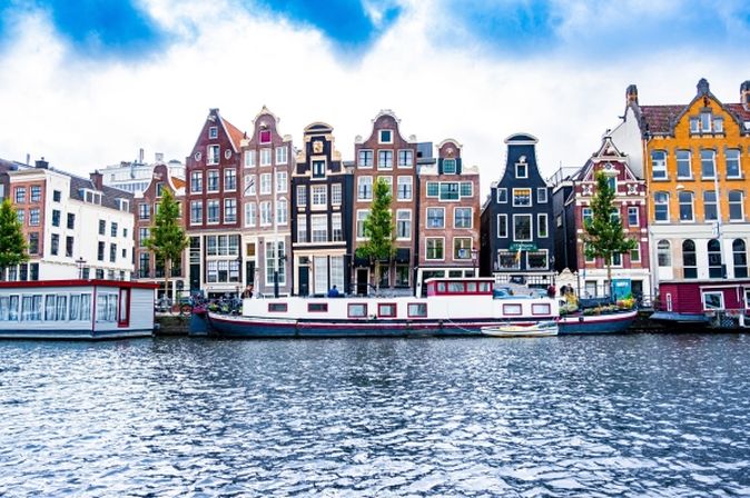 Häuserfassaden, Boote und Fluss in Amsterdam