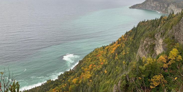 Blick auf die steilen Klippen und das türkisfarbene Meer entlang der Küste der Gaspésie-Halbinsel in Québec, Kanada, im Herbst.