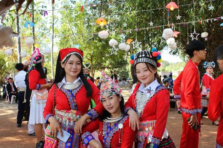 Frauen mit rotem Kostüm lächeln in Laos