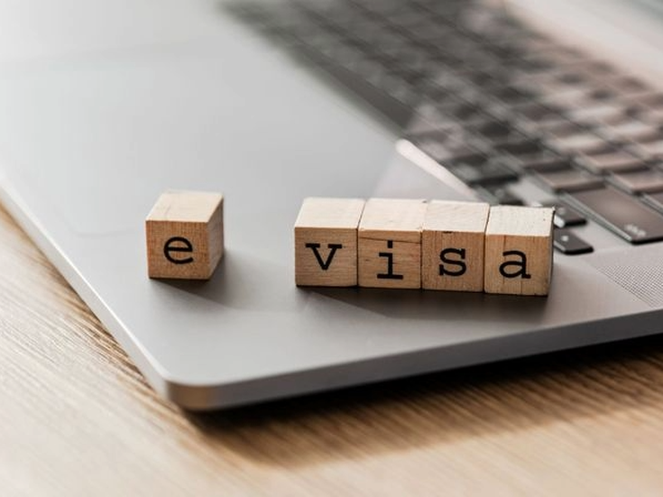 Holzwürfel mit der Aufschrift „e visa” auf einem Laptop