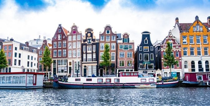 Häuserfassaden, Boote und Fluss in Amsterdam