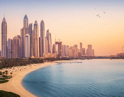 Sonnenuntergangsblick auf die Dubai Marina und das JBR-Gebiet und das berühmte Riesenrad und die goldenen Sandstrände im Persischen Golf.