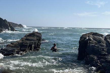 Moni im Atlantik zwischen kleinen Felsen und Wellen