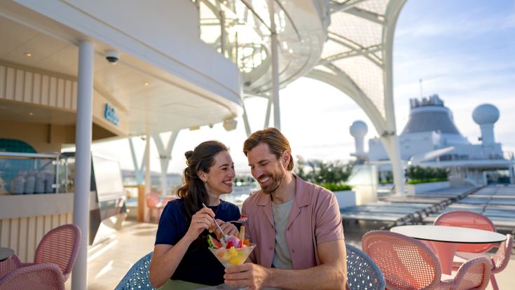 Lachende Gäste sitzen auf dem Deck von Mein Schiff Flow