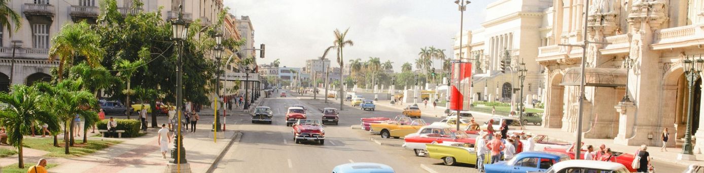 Oldtimer Autos fahren auf breitem Boulevard in der Hauptstadt Havanna auf Kuba