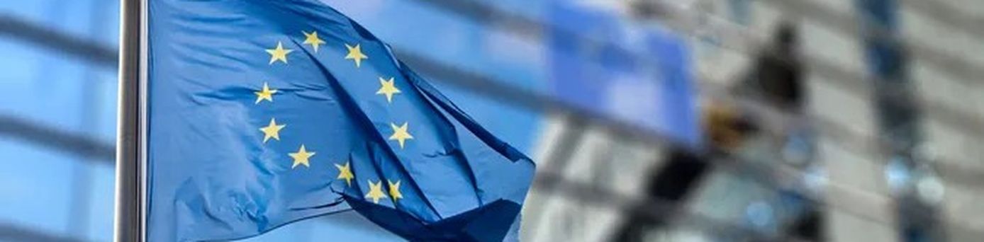 EU-Flagge vor modernem Gebäude – neue Regelungen für Geschäftsreisen in Europa