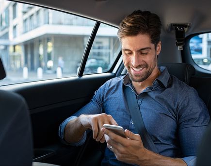 Geschäftsmann am Handy im Taxi