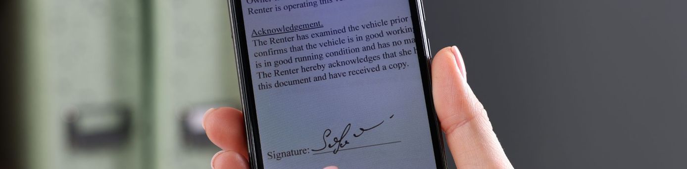 Person unterschreibt digital auf einem Smartphone – Symbol für mobiles Arbeiten und digitale Vertragsabwicklung auch unterwegs.