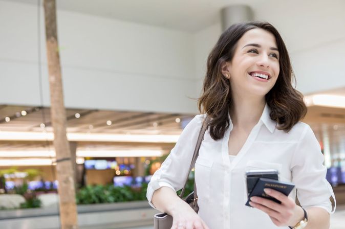 Air France-KLM Corporate Benefits Program: Frau mit Pass lächelt