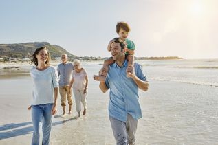 Eltern mit Kind und Großeltern gemeinsam am Strand