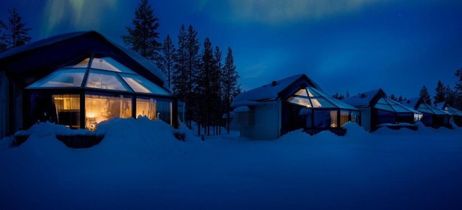 Nordlichter über schneebedeckten Glasiglus im Wald bei Nacht