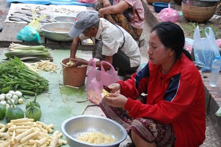 Einheimische schneidet Gemüse auf einem Markt