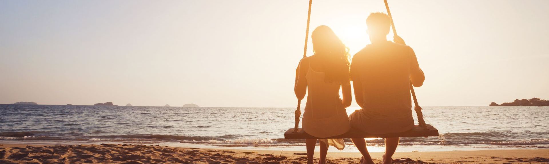 Paar-auf-einer-Schaukel-am-Strand-schaut-auf-das-Meer
