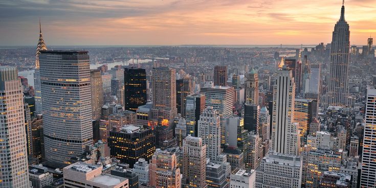 Panorama der Skyline von New York City bei Sonnenuntergang mit Empire State Building und modernen Hochhäusern.
